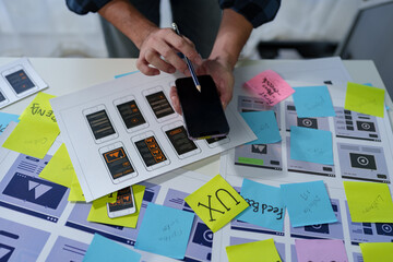 Developer, UI, UX designer, mobile app interface creation process, wireframe On the work desk for...