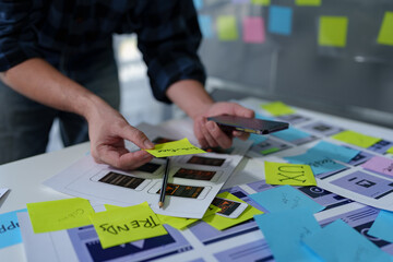 Developer, UI, UX designer, mobile app interface creation process, wireframe On the work desk for...