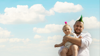 Happy father and his little baby son with funny hairs on sky background -