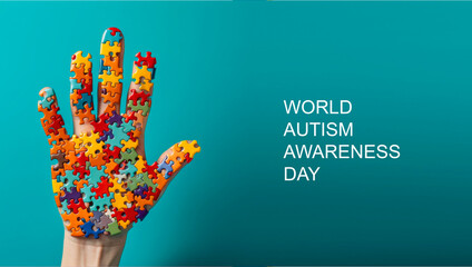 World autism awareness day banner.A human hand made from a variety of colorful puzzles . The concept of personality developmen - obrazy, fototapety, plakaty