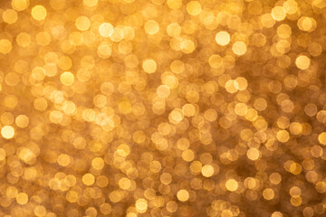 Golden abstract background with blurry bokeh circles. The atmosphere of the holiday and luxurious magic.