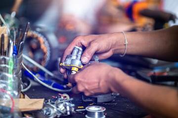 Selective focus to hand of an electric motor repairman. Mechanic is repairing an electric motor by...