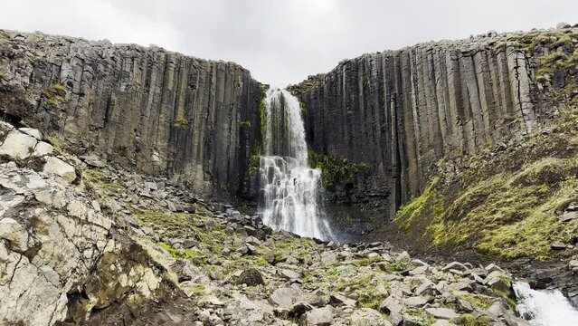 Majestic waterfall falling from a basaltic cliff in Iceland