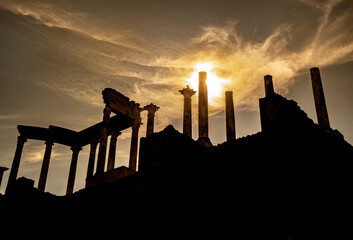 View from below of the capitals, cornice and columns of the Roman theater of Mérida, with the sun...