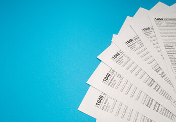 Top view of Forms 1040 U.S. Individual income tax return on a blue background