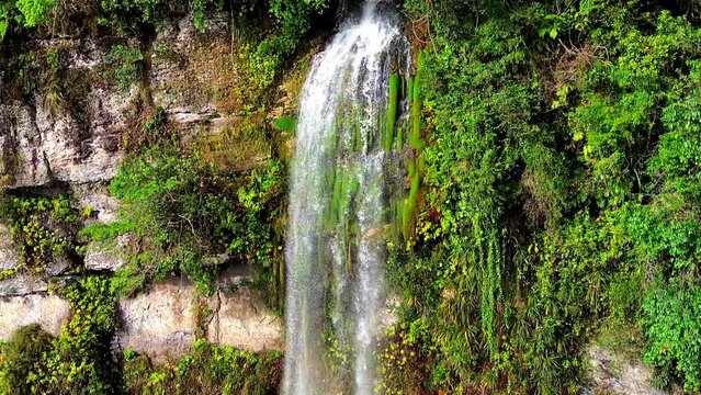 Aerial 4k video of a waterfall in Harau Valley, a popular tourist spot featuring mountains and rice fields at Sumatra island, Indonesia.