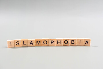 Islamophobia minimalistic concept. Isolated wooden letter blocks with word cloud Islamophobia. 