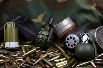 Different types of ammunition and grenades on a camouflage background. Preparing for war....