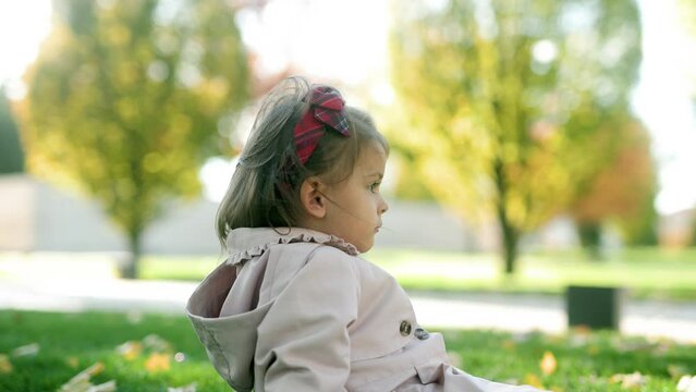 Little girl relaxing and laughing in a green park