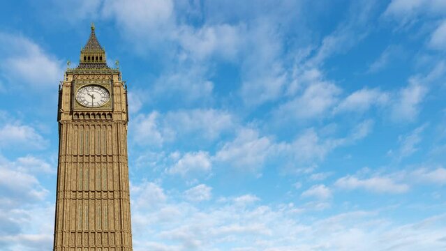 The famous Big Ben, or Elizabeth clock tower, in London, England. One hour time lapse with white clouds passing by behind. Copy space for text, image or logo on the side.