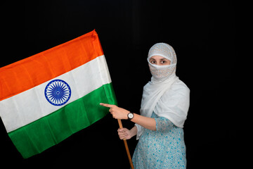 Young Indian woman holding tricolor Indian National Flag, Shows Inked Finger, flag of India, Isolated On Black Background