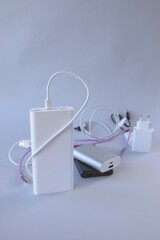 Power bank, external battery and usb wire on the table, universal mobile battery for charging gadgets, for recharging a smartphone