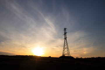 Power line against the backdrop of a landscape with a sunset, electric poles, evening, steppe Ukraine