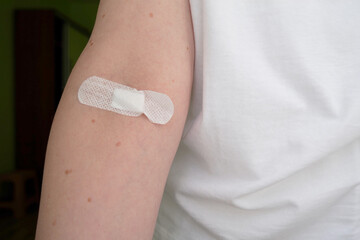 hand of a sick woman with a plaster on her arm, hospital, blood test