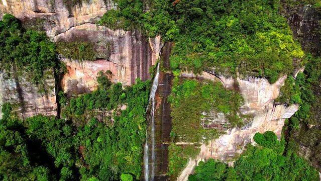 Aerial 4k video of a waterfall in Harau Valley, a popular tourist spot featuring mountains and rice fields at Sumatra island, Indonesia.