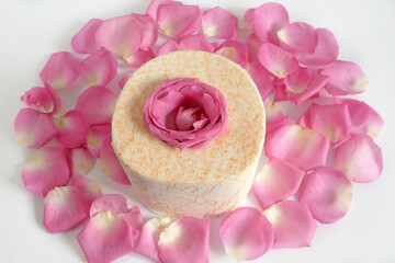 roll of toilet paper with fresh roses and petals on wршеу background, gentle and soft toilet paper with rose fragrance