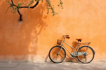Foto op Aluminium Vintage bicycle against a rustic orange wall. Nostalgic summer days. Peach Fuzz 2024 color. Design for travel posters, banner, or backdrop with free space for text © dreamdes