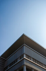 The corner of a modern building with a play on lines and geometry. Minimalist and modern architectural style.