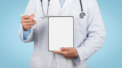 Man doctor holding blank digital tablet, blue background, mockup