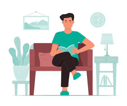 Man Sitting on Sofa and Reading a Book