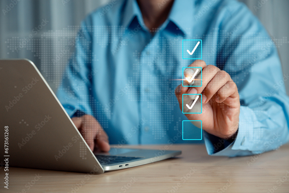 Poster businessman using laptop doing online checklist survey, check marks on checklist and filling online 