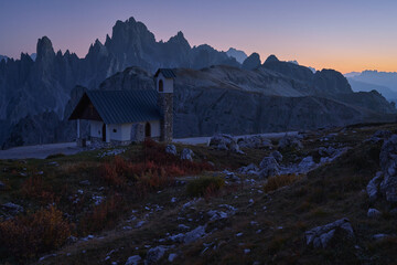 Dolomites. Evening landscape of the Italian Alps after sunset. The Cappella degli Alpini chapel in...