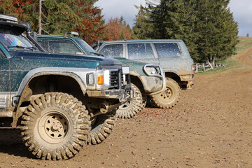 Automobile in a countryside landscape with a mud road. Off-road 4x4 suv automobile with ditry body...