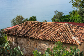 Red roof tiles on house in a rural. Colorful Spanish clay roof tiles on a building. Retro styling...