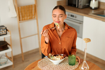 Woman tasting salad in a cozy kitchen setting