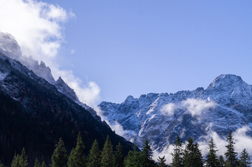 Enthralling Autumn Morning in High Tatras, Poland: Snow-Kissed Peaks and Misty Forest Canopy for Travel and Environmental Editorials