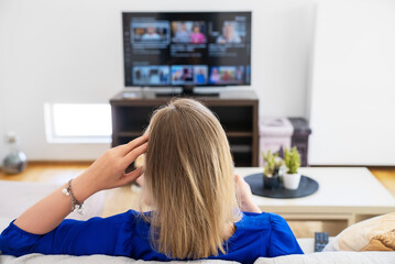 Woman watches content on her Smart TV at home.