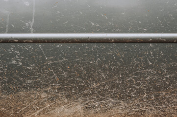 Rusty body, dirty surface in spots of a gray car. Close-up photography, abstraction.
