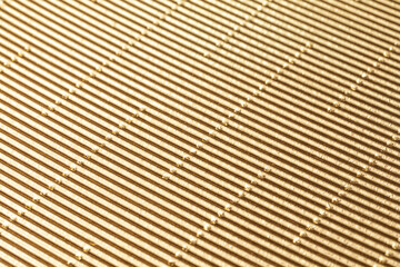 The texture of corrugated cardboard craft paper - gold. Gold corrugated cardboard useful as a background and texture.