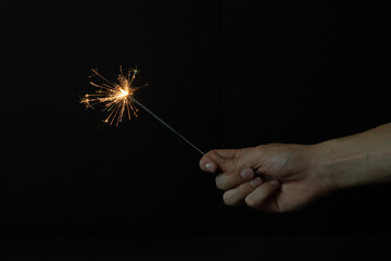 Fototapeta premium Una mano sujetando una bengala encendida