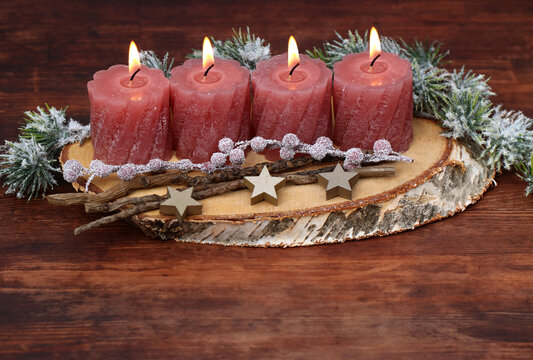 Vierter Advent: Selbstgemachte dekorative Adventsdekoration auf einer Baumscheibe.
