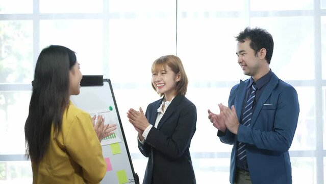 group of Asian men and women business teams applauded their business successes to their office friends Young businessmen and businesswomen applaud their congratulations to the company.