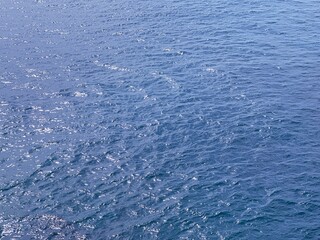 Blue sea water glittering surface.