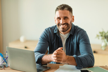 Happy Businessman Sitting Near Laptop Working Online At Modern Office