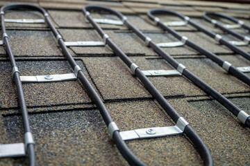 Electric roof heating system. Wire is fixed to tile. Cable for heating roof in winter. Equipment...