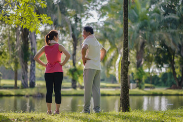 Asian Elderly Father and Daughter Enjoyed Exercising Together in The Natural Green Park. Health care and family bonding.