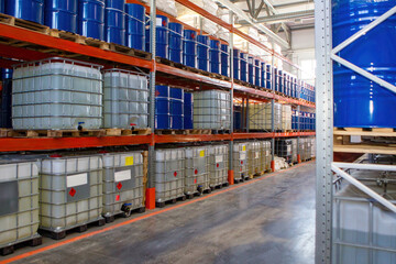 Petroleum products warehouse. Interior storage center. Racks with barrels inside warehouse. Plastic and metal barrels with oil. Warehouse hangar from inside. Crude oil is stored in logistics center