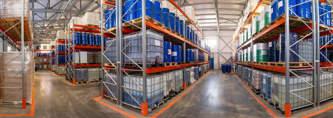 Chemical products warehouse. Panorama of industrial warehouse. Distribution center interior. Barrels with chemicals on racks. Warehouse with multi-tiered shelves. Storage in industrial hangar