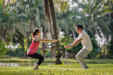 Asian Elderly Father and Daughter Enjoyed Exercising Together in The Natural Green Park. Health care and family bonding.