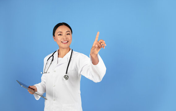 Asian Doctor Woman Using Invisible Touchscreen, Pressing Key With Finger