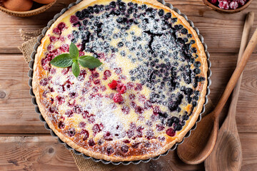 Blueberry and raspberry pie in a ceramic dish on a rustic table. Close up, top view