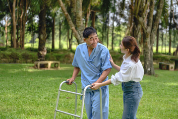 Naklejka na ściany i meble Daughter takes care of father and helps Support, Encourage him during his illness at hospital garden. The happiness of old adult patients while rehabilitation or physical therapy of retired patients.