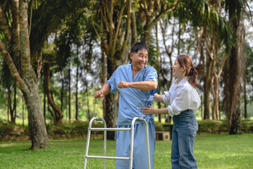 Naklejka na ściany i meble Daughter takes care of father and encourages him during his illness at hospital garden. The happiness of old adult patients while rehabilitation or physical therapy of retired patients.