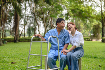 Daughter takes care of father and encourages him during his illness at hospital garden. The happiness of old adult patients while rehabilitation or physical therapy of retired patients.