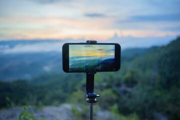 Smartphone Taking photo of mountain stream with  tripod nature view on screen at sunset - Powered by Adobe