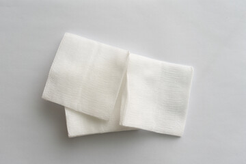 pair of foled gauze pads on white background.